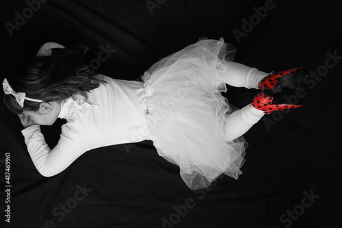 girl in flamenco shoes posing on a black background