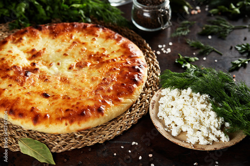 National Caucasian dish - Ossetian pies with cheese, potatoes, herbs, cottage cheese, beef, mushrooms photo