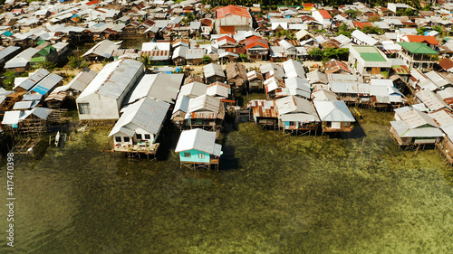 Fishing village with boats and slums with wooden houses, aerial drone. Dapa, Siargao, Philippines.