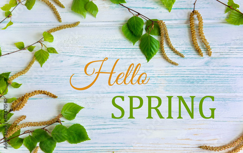 Hello spring. Greeting card with the inscription. Earrings and birch branches on the background. Postcard for mailing