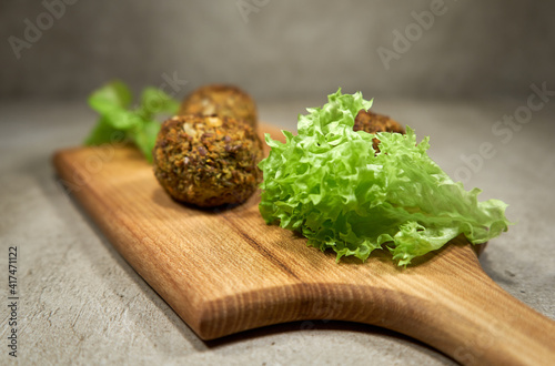 Vegetable falafels and lettuce on wooden board 