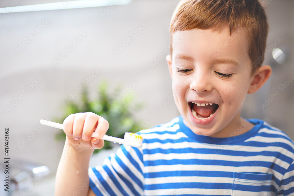 Glad mirthful boy with white healthy skin, satisfied with new toothpaste, will clean teeth, opens mouth widely, his happy expression Glad mirthful boy with white healthy skin, satisfied with new toothpaste, will clean teeth, opens mouth widely, his happy expression