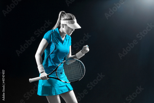 Tennis player with racket in blue costume. Woman athlete playing on grand arena background. © Mike Orlov