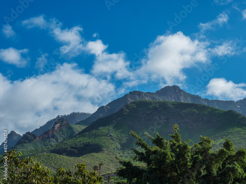 Volcanic landscape with sharp green hills and rocks near Caldera de Bandama crater with hiking trail. Gran Canaria  Spain. Sunny day  blue sky