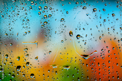 Beautiful multi-colored water droplets on a glass