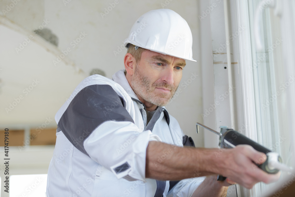 construction worker installing window in house construction worker installing window in house