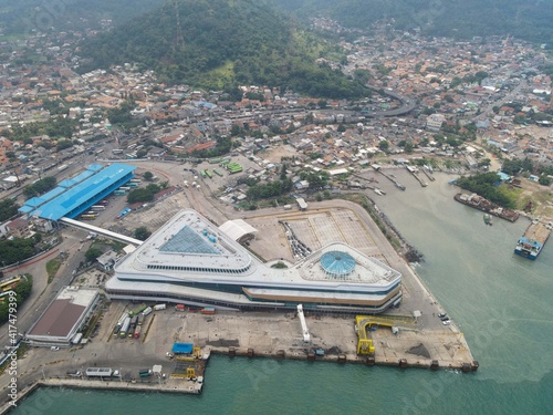 Aerial view of pelabuhan merak is a marine port and town harbor island of merak in the sunlight morning. Ferry boats, with noise cloud and cityscape.  photo