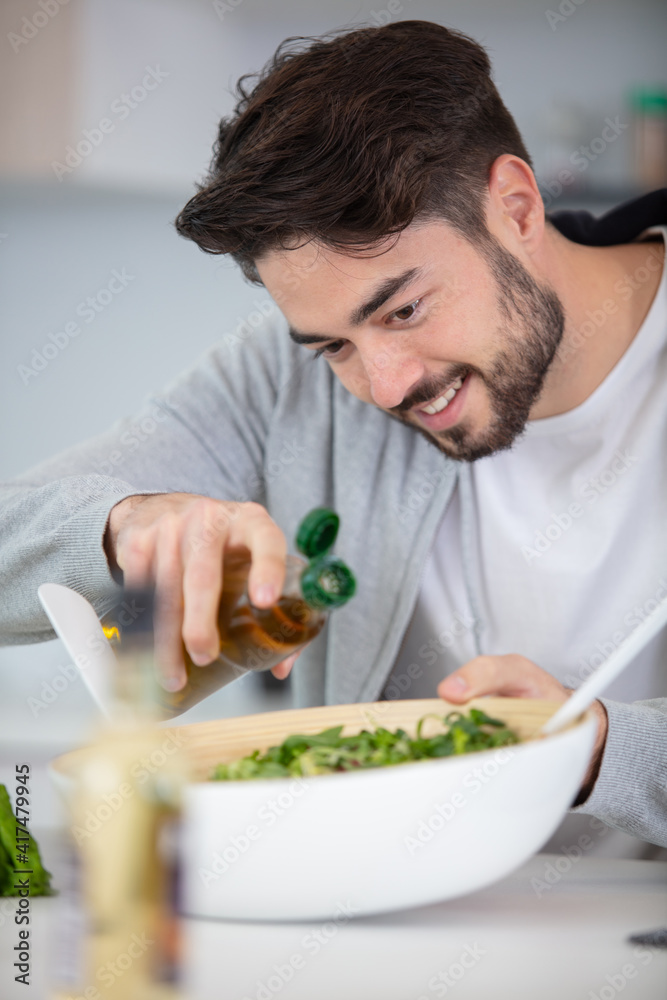 young man eating a healthy salad young man eating a healthy salad