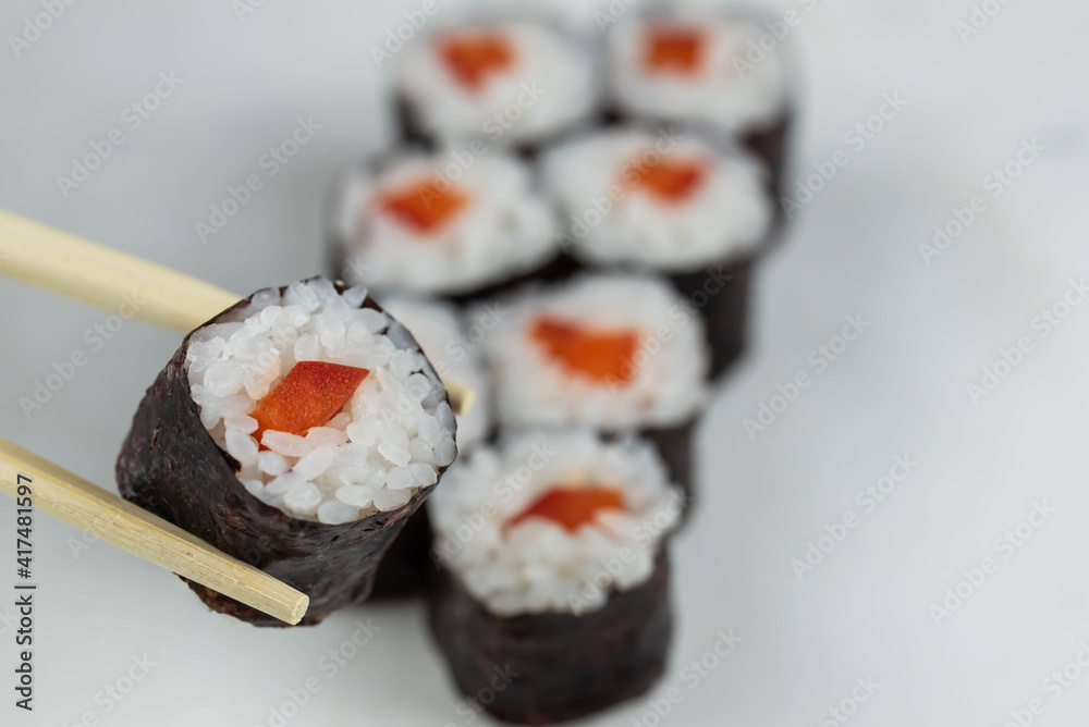 Sushi rolls prepared by professional asian chef with traditional Japanese ingredients. Salmon, rice, vegetables, sesame seeds. Sushi rolls prepared by professional asian chef with traditional Japanese ingredients. Salmon, rice, vegetables, sesame seeds.