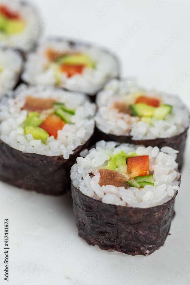 Sushi rolls prepared by professional asian chef with traditional Japanese ingredients. Salmon, rice, vegetables, sesame seeds. 