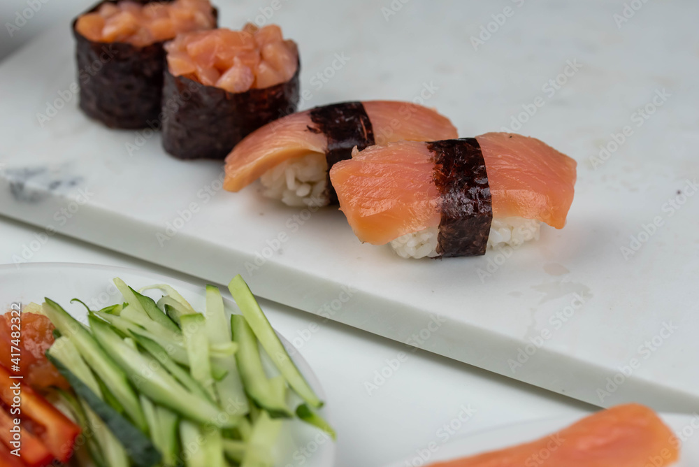 Sushi rolls prepared by professional asian chef with traditional Japanese ingredients. Salmon, rice, vegetables, sesame seeds. Sushi rolls prepared by professional asian chef with traditional Japanese ingredients. Salmon, rice, vegetables, sesame seeds.