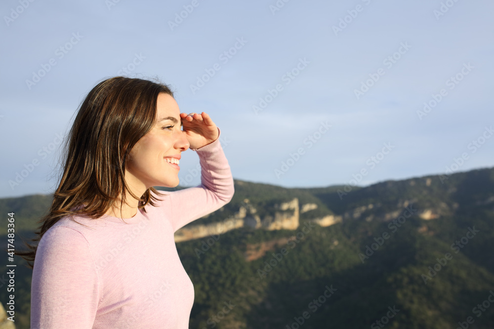 Happy woman looking forward with hand on forehead Happy woman looking forward with hand on forehead
