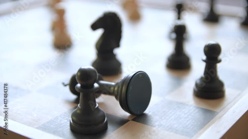 A man moves chess pieces on a chessboard. Against the background of vintage old things. Game of Chess.Player makes a move, developing chess strategy, play board game with opponent.