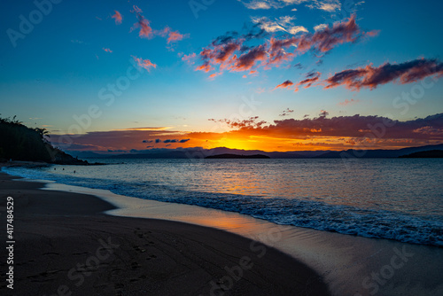 Fototapeta Naklejka Na Ścianę i Meble -  The lush colors of the sunset at Ponta do Sambaqui beach in Florianópolis, Santa Catarina, Brazil.