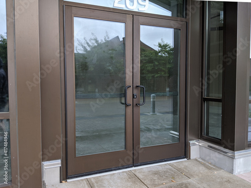 View of front doors for a business still under construction and locked with a padlock key