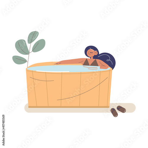 Happy young woman lying and enjoying relaxation in wooden sauna alone