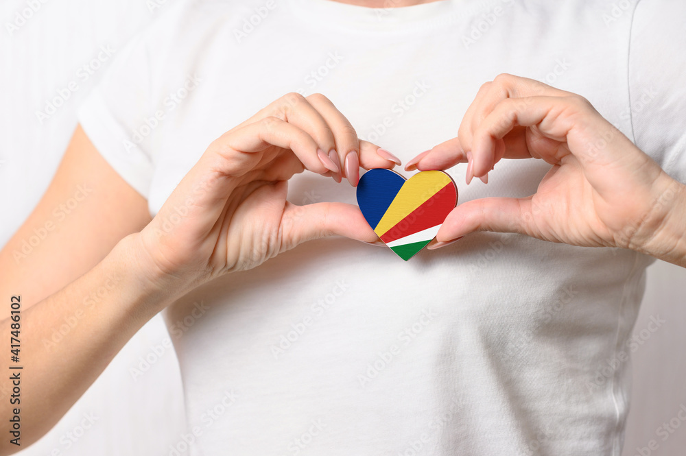 Seychelles Flag in the shape of a heart in the hands of a girl. Love Seychelles. The concept of patriotism and tourism Seychelles Flag in the shape of a heart in the hands of a girl. Love Seychelles. The concept of patriotism and tourism