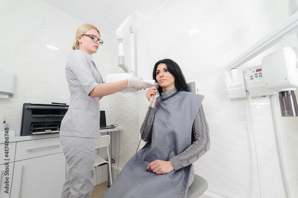 Obraz premium Dentist make jaw x-ray image for woman in dental clinic