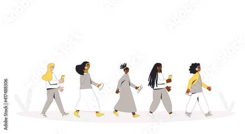 Female teenagers walking with phones and headphones walking. Girls listening to music, podcast, audiobook, lecture. Young multicultural people.