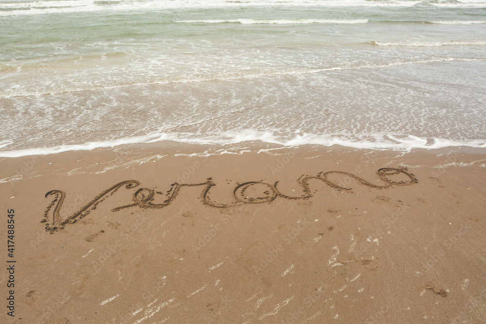 handwritten poster on sand indicating summer on the beach handwritten poster on sand indicating summer on the beach