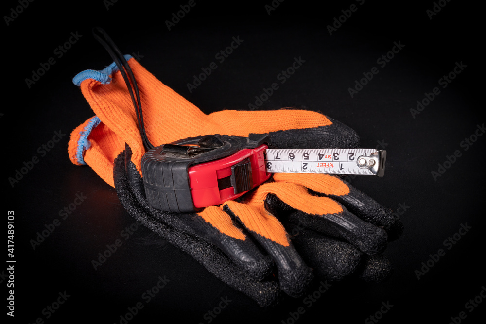 Measuring cup for taking measurements and protective gloves. Measuring and protective tools for builders. Measuring cup for taking measurements and protective gloves. Measuring and protective tools for builders.