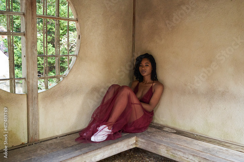 Portrait of pretty Black woman against brown wall, mid adult photo