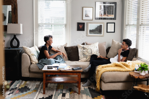Black mother son having talk in family room, on couch, middle class home photo