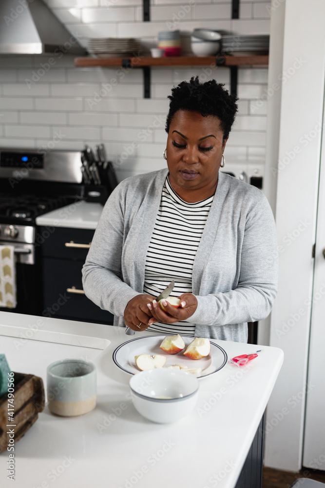 Black woman prepares a lite snack in the kitchen Black woman prepares a lite snack in the kitchen