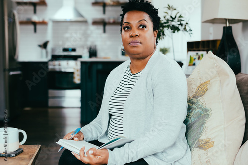 Thoughtful,focused, and concentrating woman on souch at home