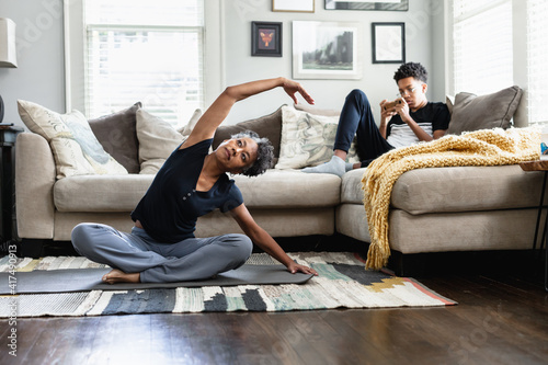 Black woman stretching and exercises in family living room photo
