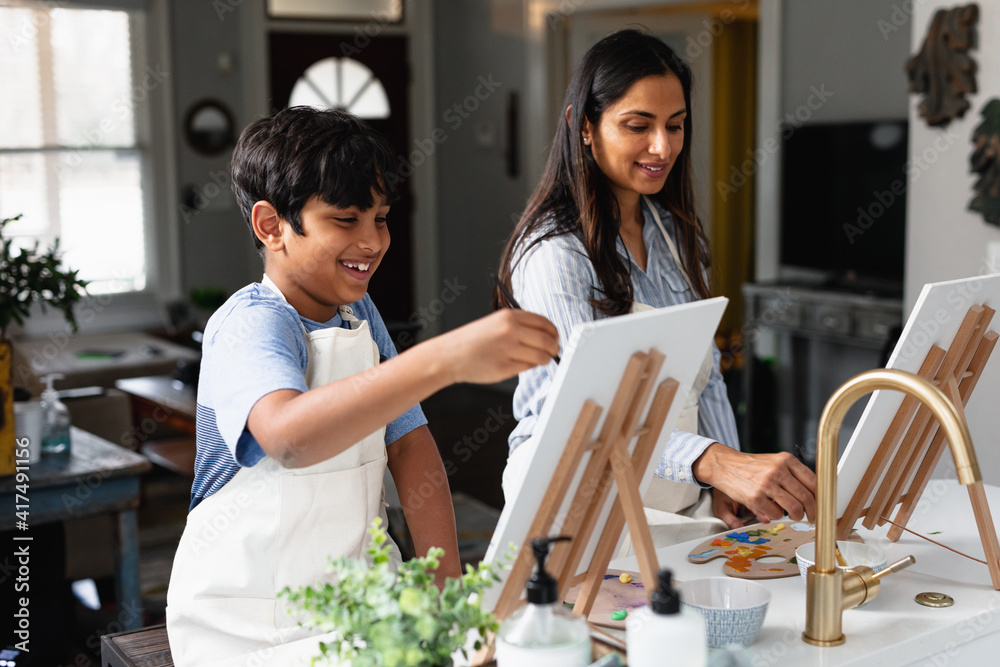 Indian mother and son laughing, painting at home, do-it-yourself Indian mother and son laughing, painting at home, do-it-yourself