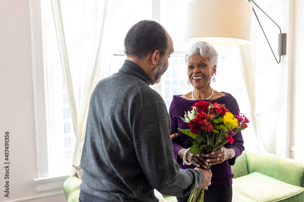 Senior man surprises wife with flowers, celebrating valentines day Senior man surprises wife with flowers, celebrating valentines day