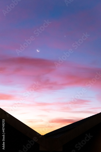 beautiful and colorful sunrise with visible moon and clouds