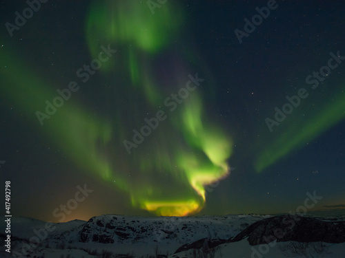 Beautiful northern lights in winter over the tunra and hills. photo