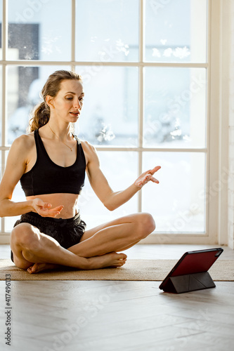 woman practicing online yoga with tablet