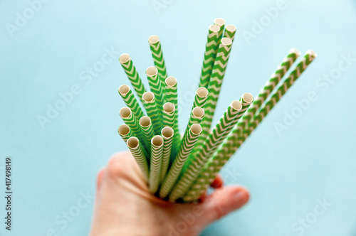 disposable green-white straws are located in the hands