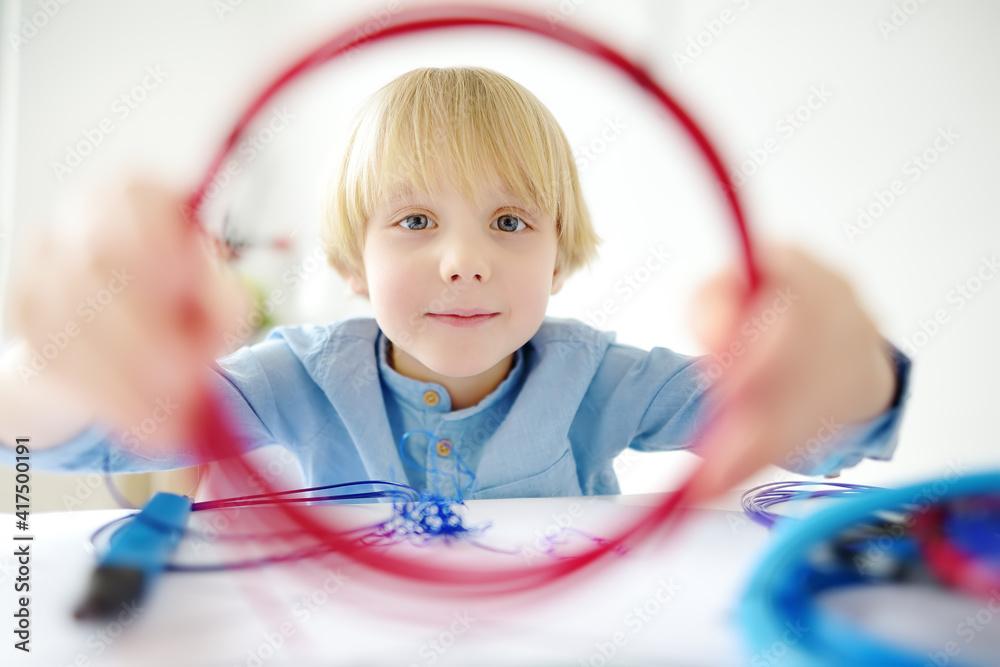 Little boy learning make model with 3d printing pen. Child playing with