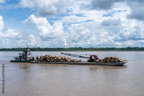Pacaya Samiria Reserve, Peru. Towboat or pushboat pushing a barge load of trees to market on the Ucayali River. photo
