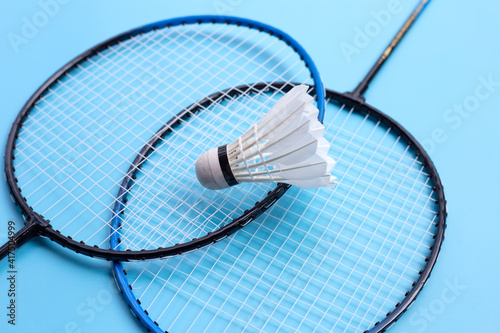 Shuttlecock and badminton rackets on blue background. © Bowonpat