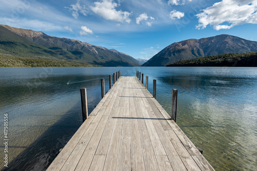 The jetty at Lake Rotoiti, Nelson Lakes National Park, New Zealand. Mountains and sky reflected in the lake.