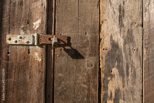 Old rusty lock on old wooden door, illustrating the concept of an abandoned place or a door closed long ago