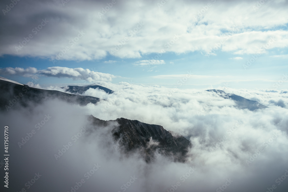 Wonderful alpine scenery with great rocks and mountains in dense low clouds. Atmospheric highlands landscape with mountain tops above clouds. Beautiful view to snow mountain peaks over thick clouds. Wonderful alpine scenery with great rocks and mountains in dense low clouds. Atmospheric highlands landscape with mountain tops above clouds. Beautiful view to snow mountain peaks over thick clouds.