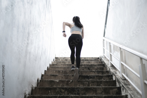 Woman in sportswear running up stairs. Health concept.
