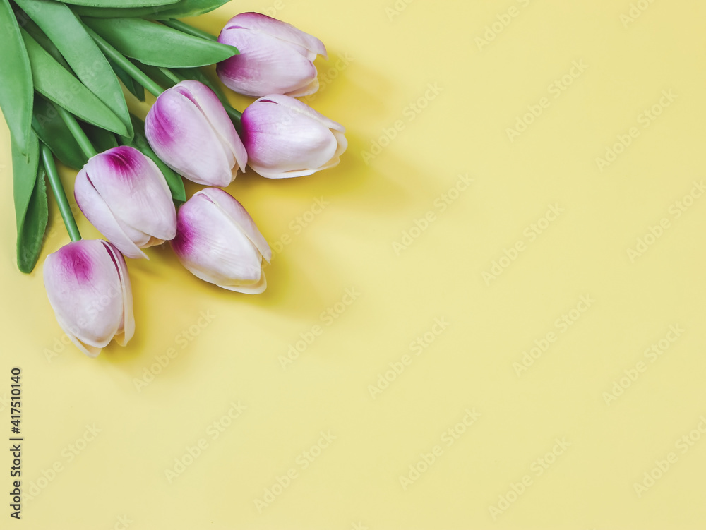  flat lay of  purple white tulip bouquet on yellow background with copy space.