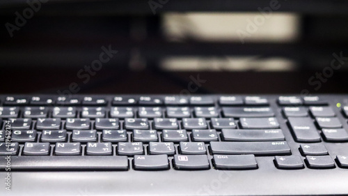 Technician need to do cleaning black keyboards part of computer by using white brush, hygiene and protection from dirty and dust, selective focus on button blurred background.	Electronic tool concept