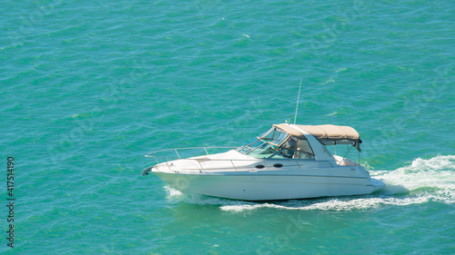Powerboat or motorboat. Fishing boat on ocean waves. Ocean or Gulf of Mexico. Spring break or Summer vacations in Florida. Blue-turquoise sea water. Sunny day.