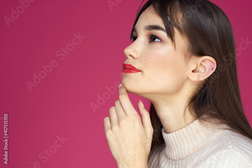 Woman with red lips bright makeup white blouse long hair pink background