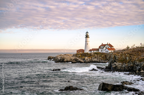 Lighthouse on a cliff top against a cloudy sky on the Atlantic coast in Portland Maine in New England