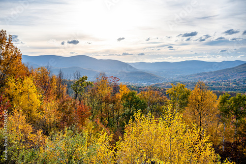 Picturesque Autumn Maple Grove and Valley Town in the hilly countryside of Vermont