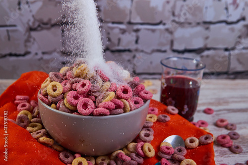 bad breakfast of colored cereals falling sugar with red fruit juice